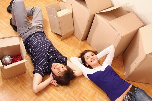 Local movers carrying furniture through a residential entrance in St Helier